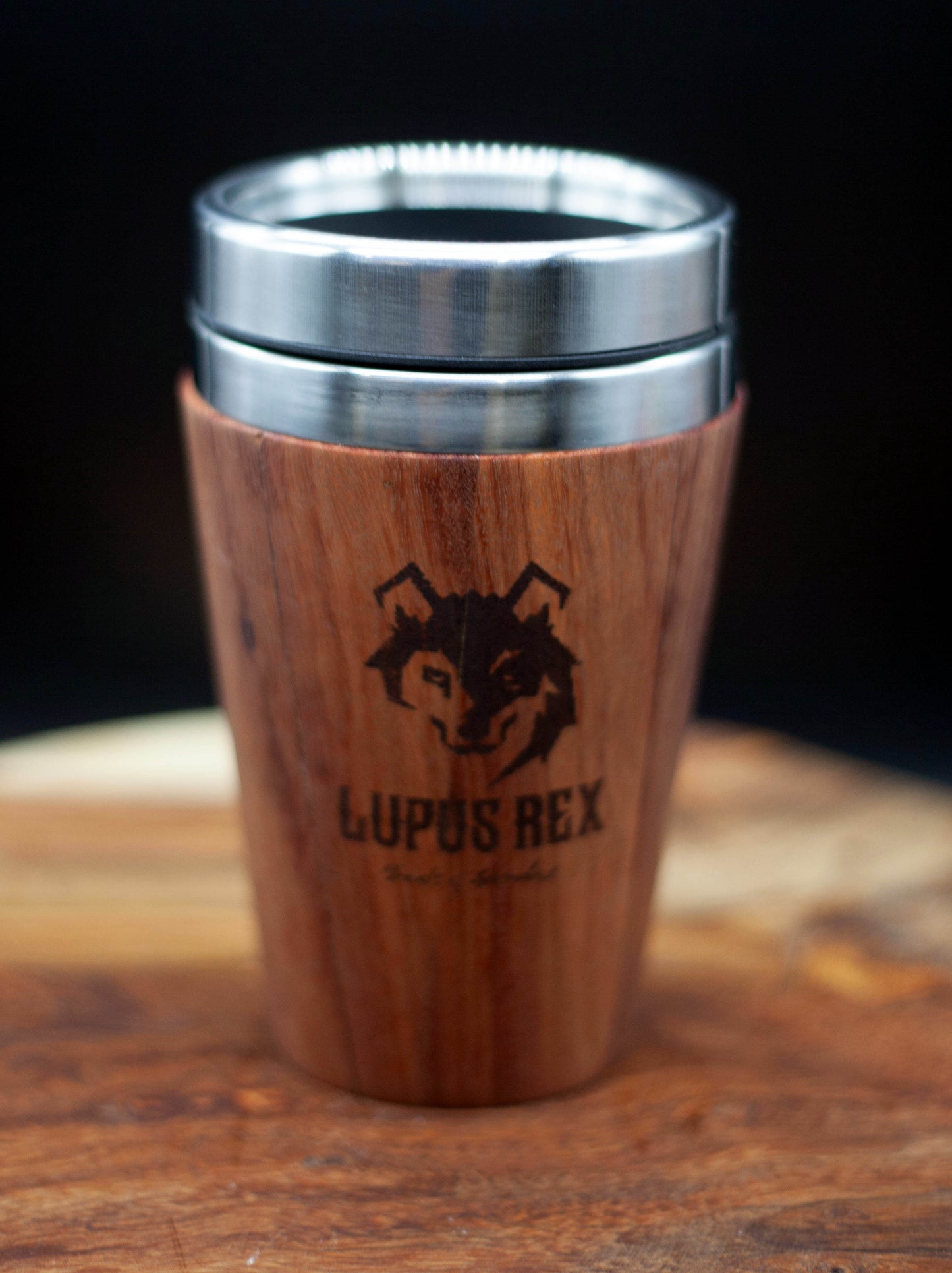 Australian handcrafted light to mid brown coloured timber exterior travel mug with stainless steel interior. Holds approx. 295ml or 10 oz which is roughly a small to medium at most cafes. Not dishwasher safe. Hand wash only. Don't immerse timber exterior in water. Lupus Rex logo with wolf head branded on timber