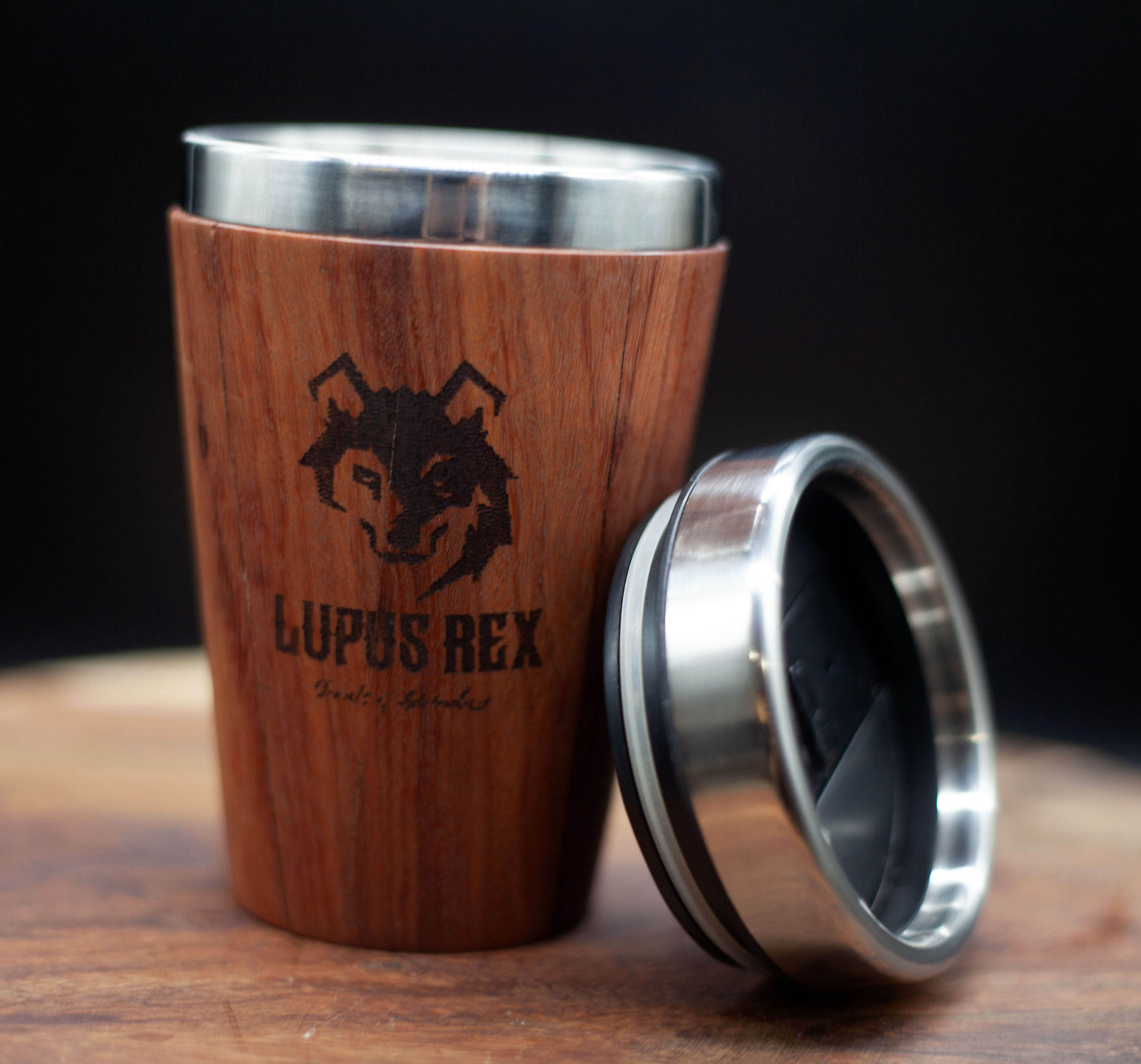 Australian handcrafted light to mid brown coloured timber exterior travel mug with stainless steel interior. Holds approx. 295ml or 10 oz which is roughly a small to medium at most cafes. Not dishwasher safe. Hand wash only. Don't immerse timber exterior in water. Lupus Rex logo with wolf head branded on timber