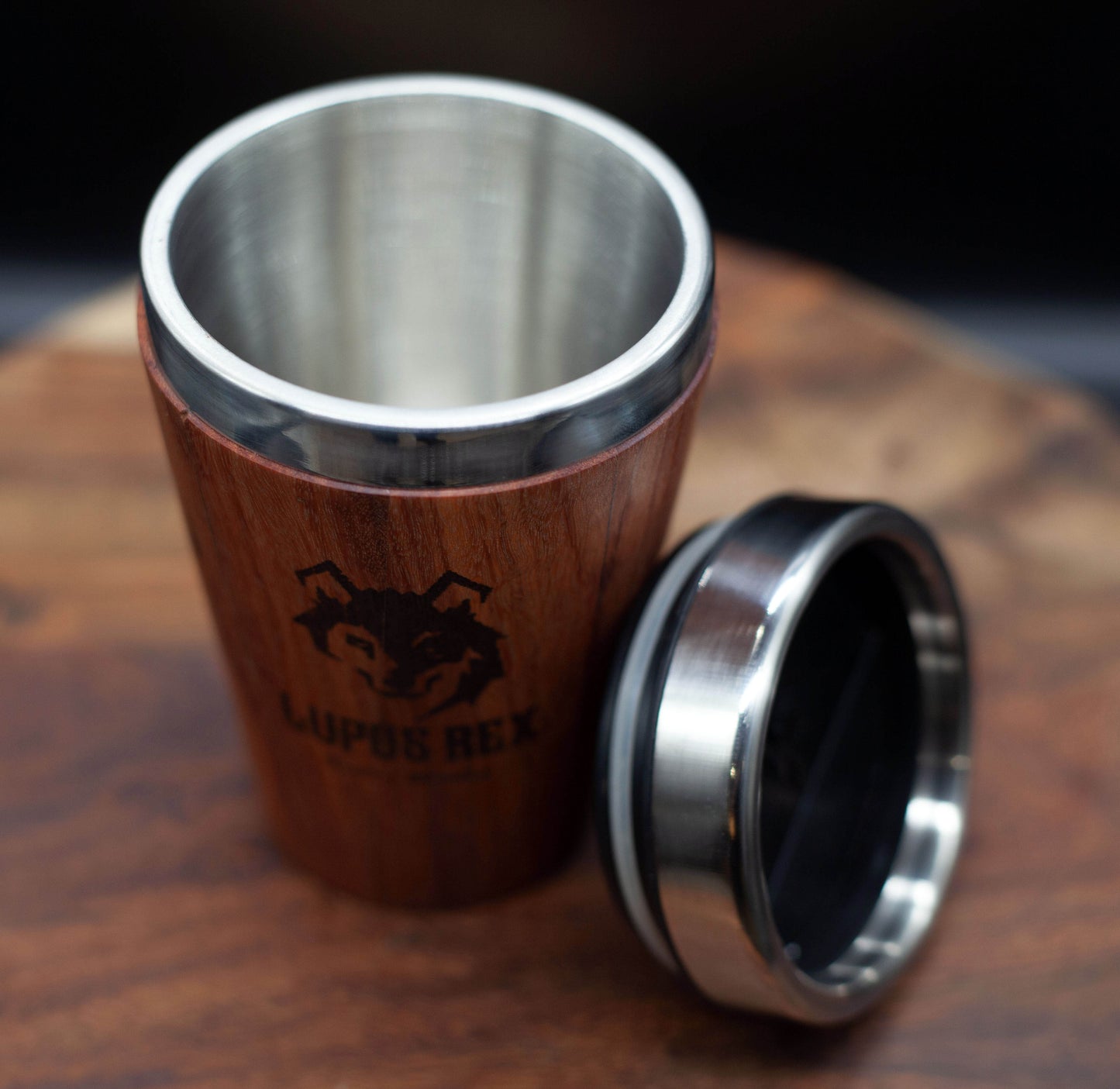 Australian handcrafted light to mid brown coloured timber exterior travel mug with stainless steel interior. Holds approx. 295ml or 10 oz which is roughly a small to medium at most cafes. Not dishwasher safe. Hand wash only. Don't immerse timber exterior in water. Lupus Rex logo with wolf head branded on timber