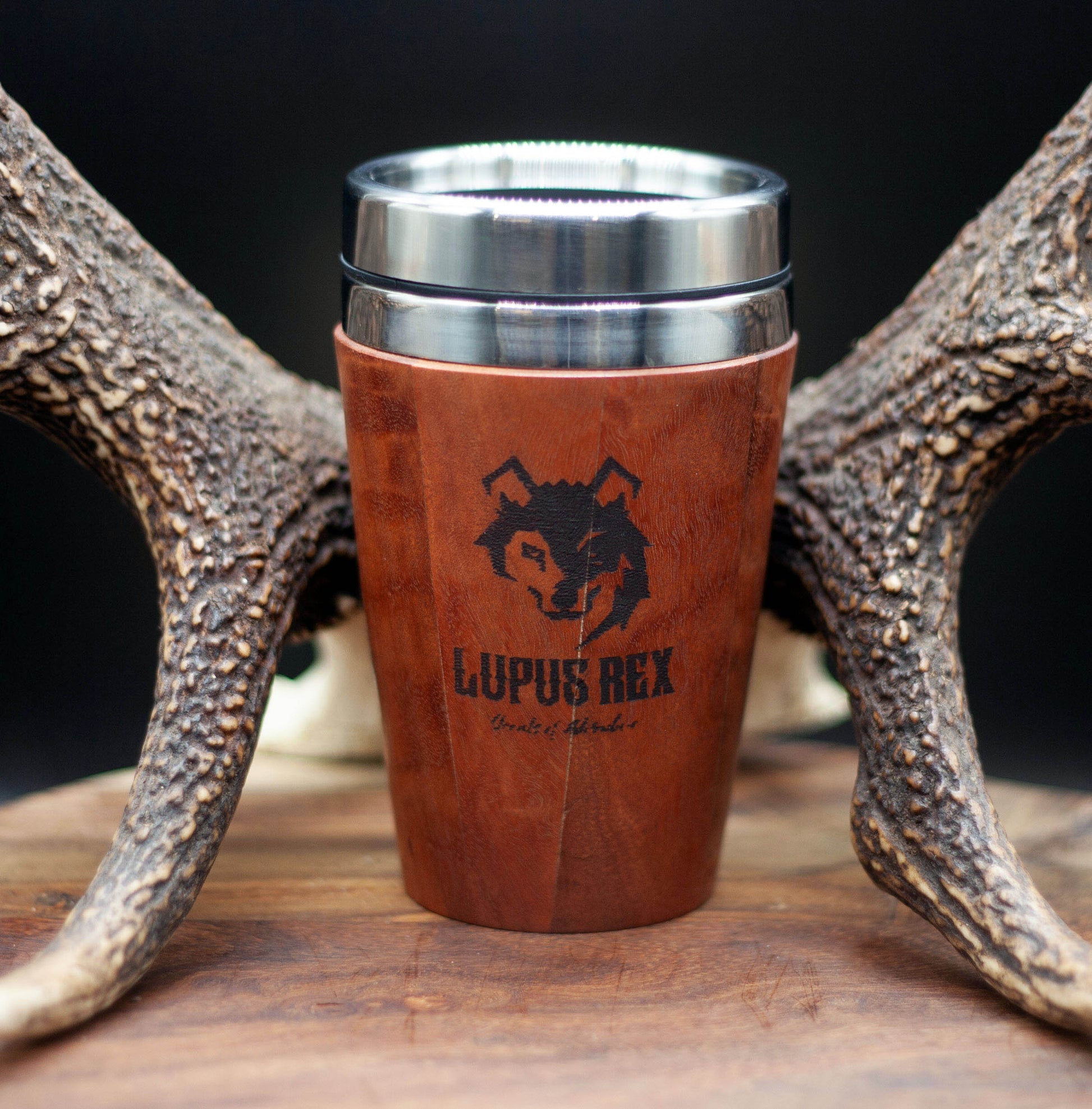 Reddish brown timber exterior handcrafted travel mug with stainless steel interior. Holds approx. 295ml or 10 oz which is roughly a small to medium at most cafes. Not dishwasher safe. Hand wash only. Don't immerse timber exterior in water. Lupus Rex logo with wolf head branded on  timber